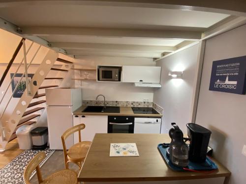 une petite cuisine et salle à manger avec une table et des chaises dans l'établissement 90m2 dans résidence avec piscine Plein sud avec terrasse, au Croisic