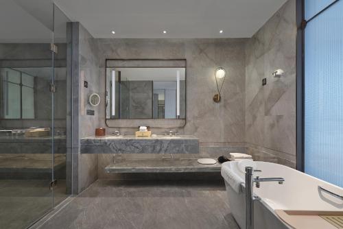 a bathroom with a tub and a sink and a shower at Dongguan DongCheng International Hotel - Free shuttle buses for executive room guests during Canton Fair in Dongguan