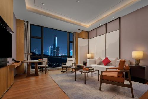 a living room with a view of a city at Dongguan DongCheng International Hotel - Free shuttle buses for executive room guests during Canton Fair in Dongguan