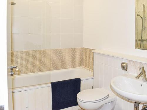 a bathroom with a toilet and a sink and a tub at Cape A2 Westbay Club, a 2 bedroom cottage, Isle of Wight in Yarmouth