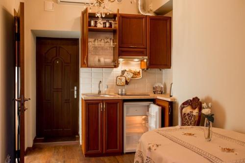 a kitchen with wooden cabinets and a bed in a room at Lviv hollidays Galytska in Lviv