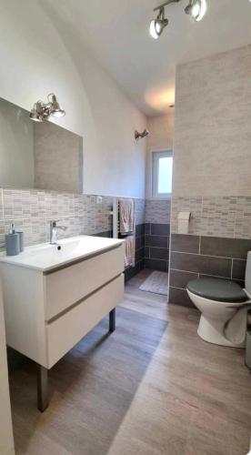 une salle de bain avec un lavabo blanc et des toilettes dans l'établissement Le Musoir, au Tréport