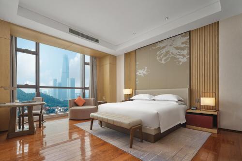 a bedroom with a large bed and a large window at Dongguan DongCheng International Hotel - Free shuttle buses for executive room guests during Canton Fair in Dongguan