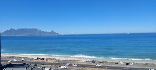 a view of a beach and the ocean with cars parked at Infinity Beachfront 607 - Self Catering Unit in Bloubergstrand