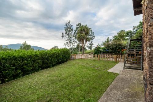 リエルガネスにあるSenda del pasiegoの木製の柵と芝生の庭のある庭