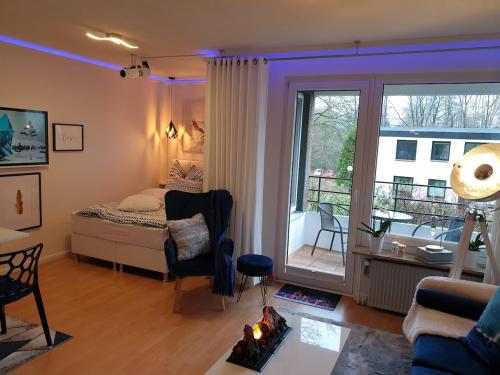 グリュックスブルクにあるModern und am Strand Balkon,PPのベッドとリビングルームのある寝室