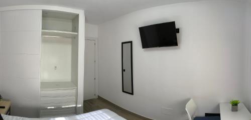 a white room with a tv on a wall at Habitaciones Torija in Torija
