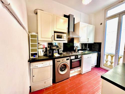 une cuisine avec des armoires blanches et une machine à laver dans l'établissement ApartHotel Riviera - PONT VIEUX 2 - Old town - Charm 2 Bedrooms Apartement AC - 5mn beach, à Nice