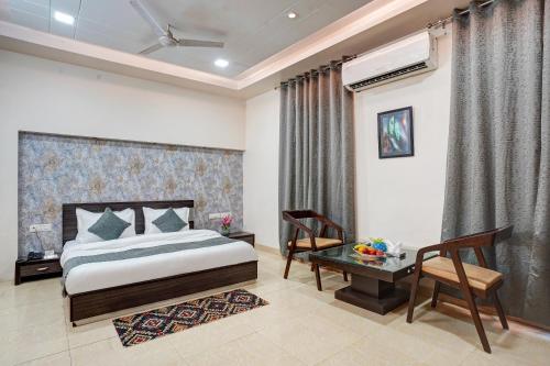 a bedroom with a bed and a table and a desk at Shyama inn by Rivlet in New Delhi