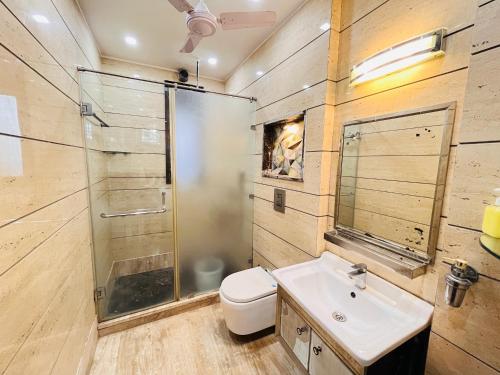 a bathroom with a toilet and a sink and a shower at South Haven Residency - South Extension South Delhi in New Delhi