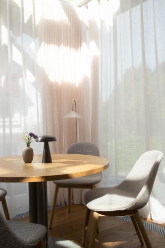 a table and chairs in a room with a window at Hotel Haus am See in Nonnenhorn
