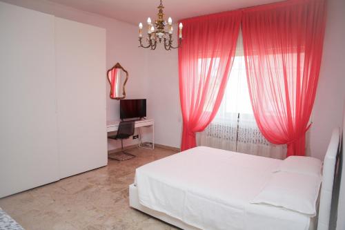 a bedroom with a bed and a window with pink curtains at Villa Fiorita in Mediglia