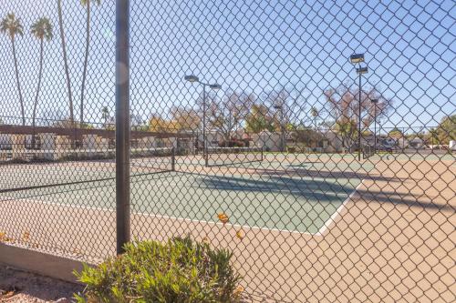 a tennis court behind a chain link fence at Cozy House Pool Spa Tennis & Pickleball Courts in Tempe