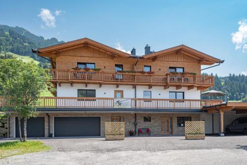 Una casa grande con un balcón en la parte superior. en M&M Appartements Brixental, en Westendorf