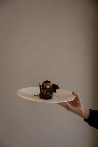 a person holding a piece of chocolate cake on a plate at Hotel Haus am See in Nonnenhorn