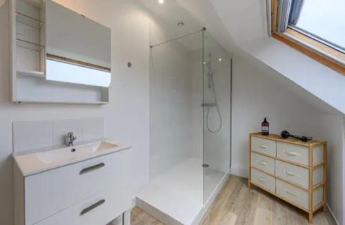 une salle de bain blanche avec un lavabo et une douche dans l'établissement Le Cocon du Golfe, maison rénovée avec jardin, à Vannes