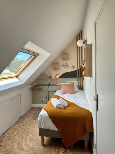 une chambre avec un lit dans un grenier dans l'établissement Le Cocon du Golfe, maison rénovée avec jardin, à Vannes