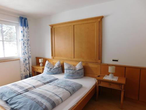 a bedroom with a large bed with a wooden headboard at Schernhof in Söll
