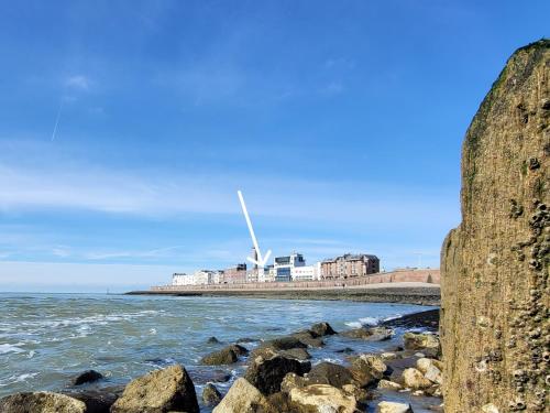 a view of the beach with a wind turbine in the background at Zeezicht in Vlissingen