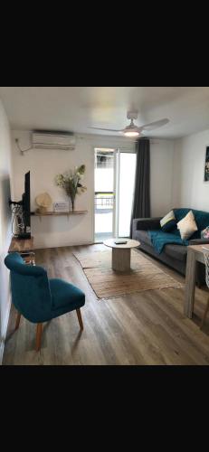 a living room with a couch and a blue chair at Pépite citadine à St Pierre in Saint-Pierre