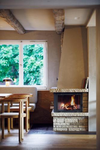 a fireplace in a room with a table and a window at Hotel Haus am See in Nonnenhorn