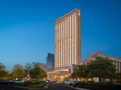 a rendering of a tall building with cars parked in front at Dongguan DongCheng International Hotel - Free shuttle buses for executive room guests during Canton Fair in Dongguan