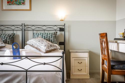 a bedroom with a bed and a chair at Villa San Giorgio in SantʼAmbrogio di Valpolicella