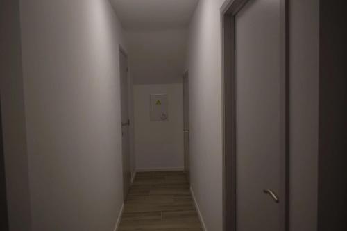 an empty hallway with a white wall and a door at Charming house in Hoegaarden with BBQ and garden in Hoegaarden
