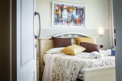 a bedroom with a bed with pillows and a painting on the wall at Villa San Giorgio in SantʼAmbrogio di Valpolicella