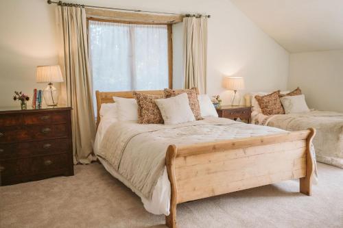 a bedroom with two beds and a window at River Cottage By Birch Stays in Glasbury