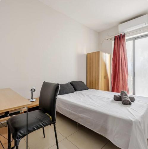 a bedroom with a bed and a desk and a chair at Elegant central apartment in Sliema