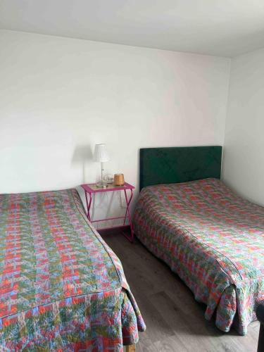 une chambre avec deux lits et une table avec une lampe dans l'établissement Nice place 80m2- 2 to 8 beds- 30min from Paris 15min Aeroport Orly, à Créteil