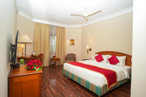 a hotel room with a bed and a desk at Ambassador Ajanta Hotel, Aurangabad in Aurangabad