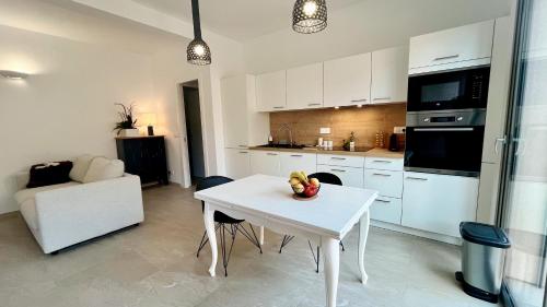 - une cuisine blanche avec une table et une chaise blanches dans l'établissement Appartement avec jardin proche de la mer, à Agay