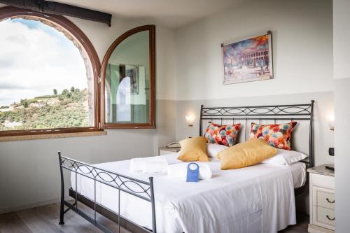a bedroom with a bed with white sheets and a window at Villa San Giorgio in SantʼAmbrogio di Valpolicella