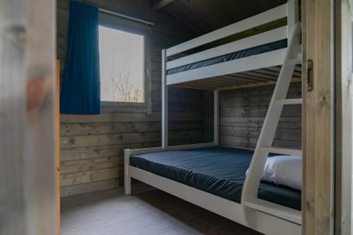 a bunk bed in a cabin with a window at Camping Sudersé in Workum