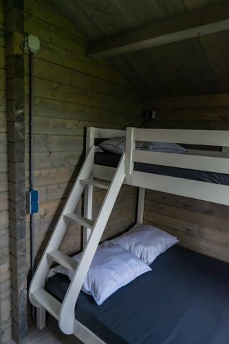 a bunk bed in a wooden cabin with two pillows at Camping Sudersé in Workum