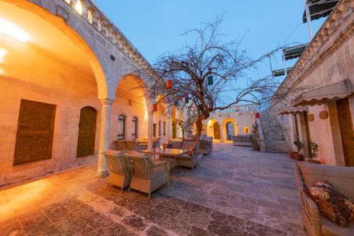 un cortile con tavoli e sedie in un edificio di Narlı Ev Butik Otel a Şanlıurfa