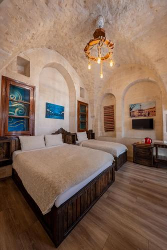 a large bedroom with two beds and a chandelier at Narlı Ev Butik Otel in Urfa