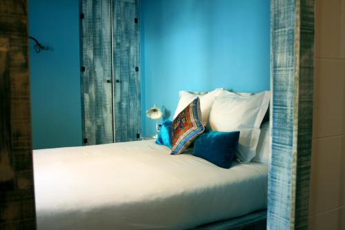 a white bed with blue walls and pillows at La Posada de Quijada in Granada