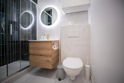 une salle de bain blanche avec toilettes et douche dans l'établissement Sd Appartement familiale au coeur de la rue Saint Denis, à Paris