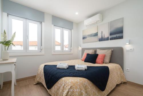 a bedroom with a bed with two towels on it at Charming Bright House w/ Garden by HostWise in Porto