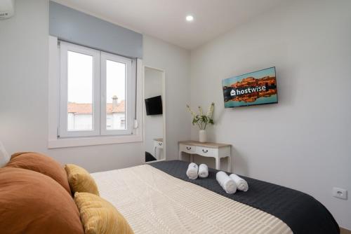 a bedroom with a bed with two white towels on it at Charming Bright House w/ Garden by HostWise in Porto