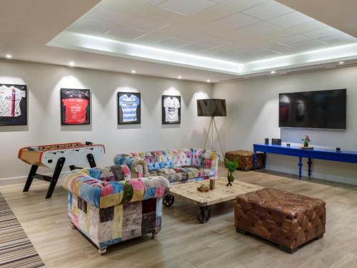 a living room with couches and a ping pong table at Renaissance Paris Hippodrome de St. Cloud Hotel in Rueil-Malmaison