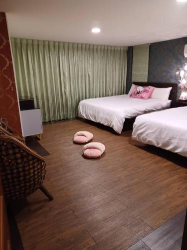 a room with two beds with pink pillows on the floor at Q寶の家 home Sweet home in Dongshan