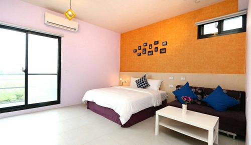 a bedroom with a bed and a couch at Happiness 210 B&B in Dongshan