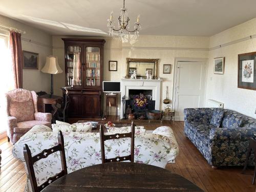 a living room with a couch and a table at Peacocks Tearoom and Fine B&B in Ely
