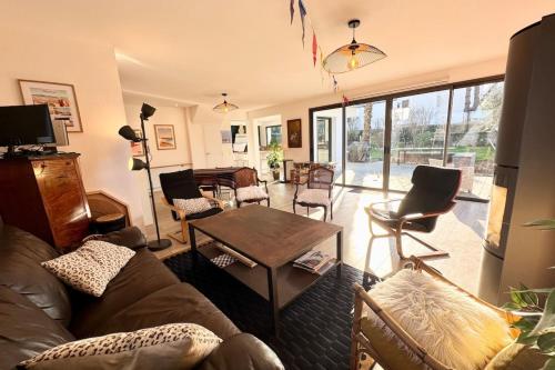 un salon avec un canapé et une table dans l'établissement Spacieuse maison - Jardin - 5min des plages, à Ploemeur