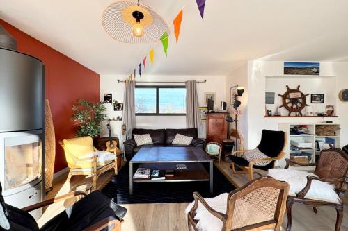 un salon avec un canapé et des chaises dans l'établissement Spacieuse maison - Jardin - 5min des plages, à Ploemeur