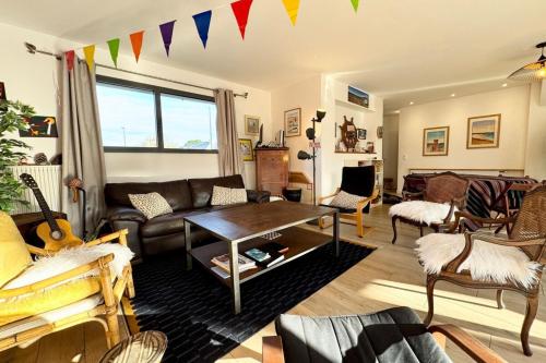 un salon avec un canapé et une table dans l'établissement Spacieuse maison - Jardin - 5min des plages, à Ploemeur